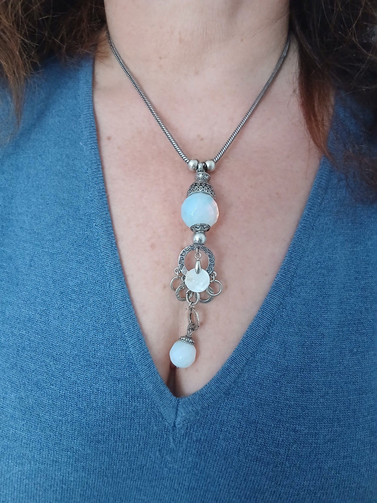 Collier pendentif opaline bleu pâle et filigrane argenté porté par un modèle